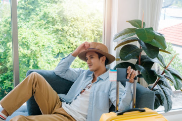 A,Man,With,Yellow,Luggage.,Handsome,Asian,Male,In,Denim