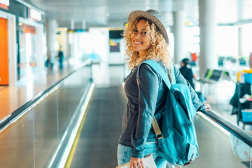 Cheerful,Young,Adult,Woman,Travel,At,The,Airport,With,Backpack.