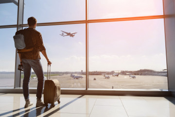 Calm,Male,Tourist,Is,Standing,In,Airport,And,Looking,At