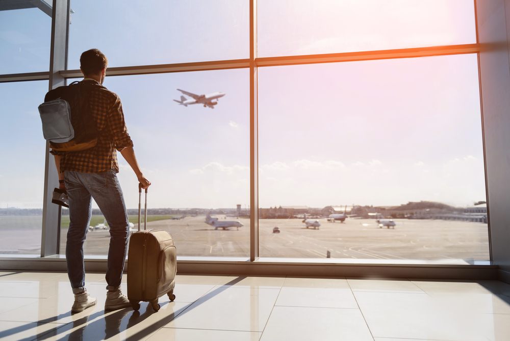 Calm,Male,Tourist,Is,Standing,In,Airport,And,Looking,At