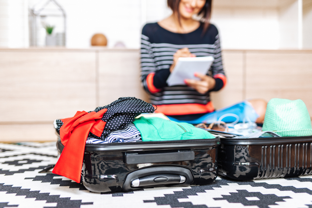 Beautiful,Young,Woman,Packing,Her,Stuff,Into,A,Big,Suitcase.