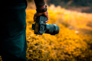 Photographer,Holding,His,Camera,With,Blur,Background,,Photography,Concept,Image,