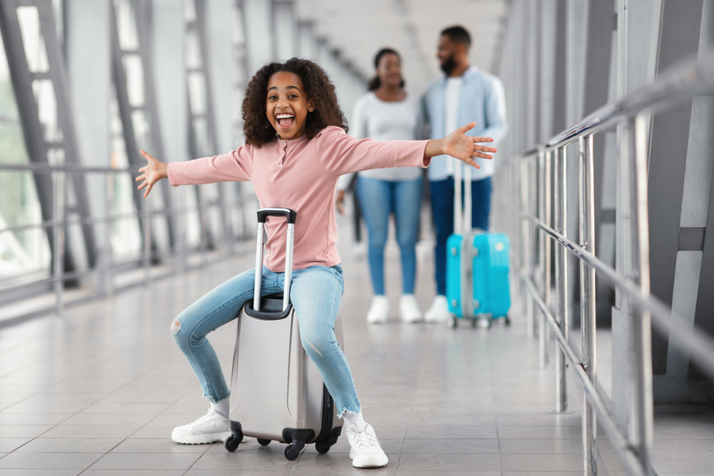 Long-awaited,Vacation,Trip.,Joyful,Excited,Black,Girl,Sitting,On,Bag