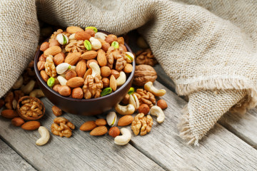 Wooden,Bowl,With,Nuts,On,A,Wooden,Background,,Near,A