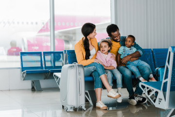 Smiling,African,American,Family,With,Baggage,And,Kids,Sitting,In