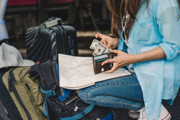 Woman,Travel,,,Girl,With,Backpack,Counting,Us,Dollars,Money