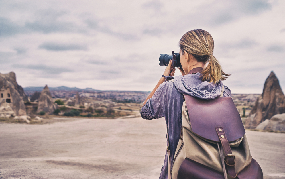 Traveling,And,Photography.,Young,Woman,With,Camera,And,Backpack,Taking