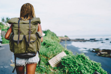 Back,View,Of,African,American,Female,Tourist,With,Backpack,Exploring