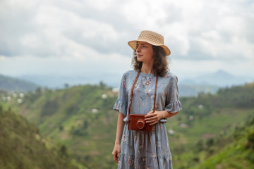 Happy,Young,Female,Traveler,In,Hat,With,Photo,Camera,Against