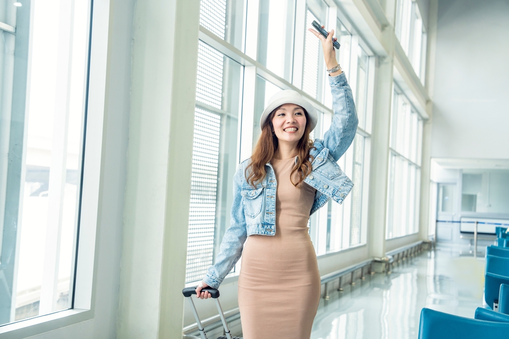 Asian,Female,Tourist,Backpacking,In,Denim,Jacket,Dress,Dragging,Luggage,