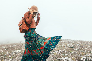 Boho,Woman,Wearing,Hat,And,Leather,Jacket,Walking,In,Mountains.