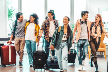 Young,Group,Of,Tourists,With,Suitcases,Arriving,At,Youth,Hostel