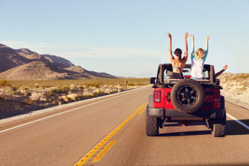 Rear,View,Of,Friends,On,Road,Trip,Driving,In,Convertible