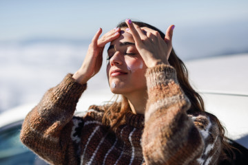 Young,Woman,Applying,Sunscreen,On,Her,Face,In,Snowy,Mountains