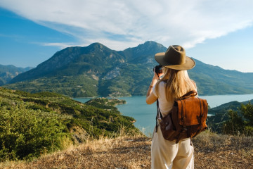 Woman,Photographer,With,Big,Backpack,Taking,Photo,Of,Mountains,And