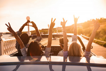 Group,Of,Happy,Young,Friends,In,Cabriolet,With,Raised,Hands