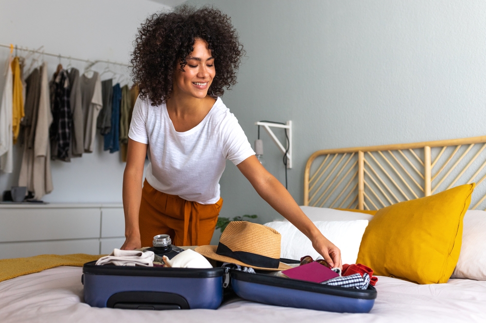 Happy,African,American,Young,Woman,Packing,Suitcase,At,Home.,Preparing