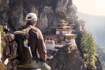 Tourist,Sitting,On,His,Back,Watching,Tiger`s,Nest,Temple,In