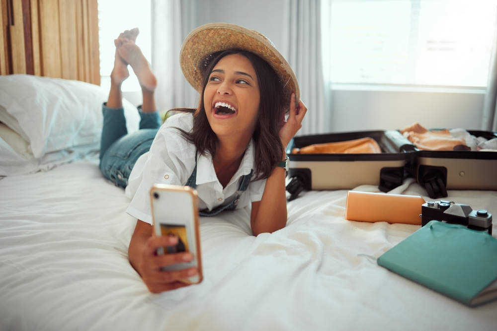 Travel,,Suitcase,And,Phone,With,Woman,In,Bedroom,Of,Hotel