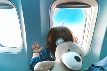Little,Toddler,Boy,Looking,Out,An,Airplane,Window,While,Flying