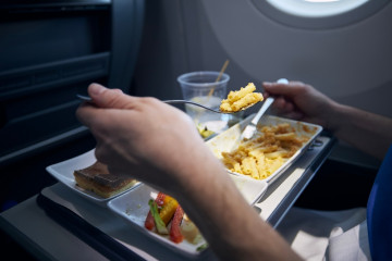 Passenger,Eating,Airline,Meal,With,Metal,Cutlery.,Selective,Focus,On