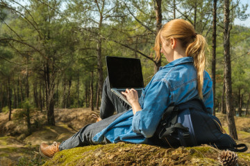 Young,Woman,Sitting,On,Ground,At,Forest,And,Working,On