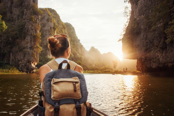 Woman,With,Backpack,Swims,On,Boat,Among,Karst,Mountains,To
