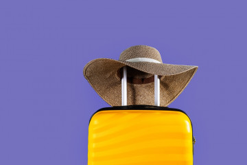 Bright,And,Stylish,Cabin,Size,Suitcase,With,Straw,Hat,Against
